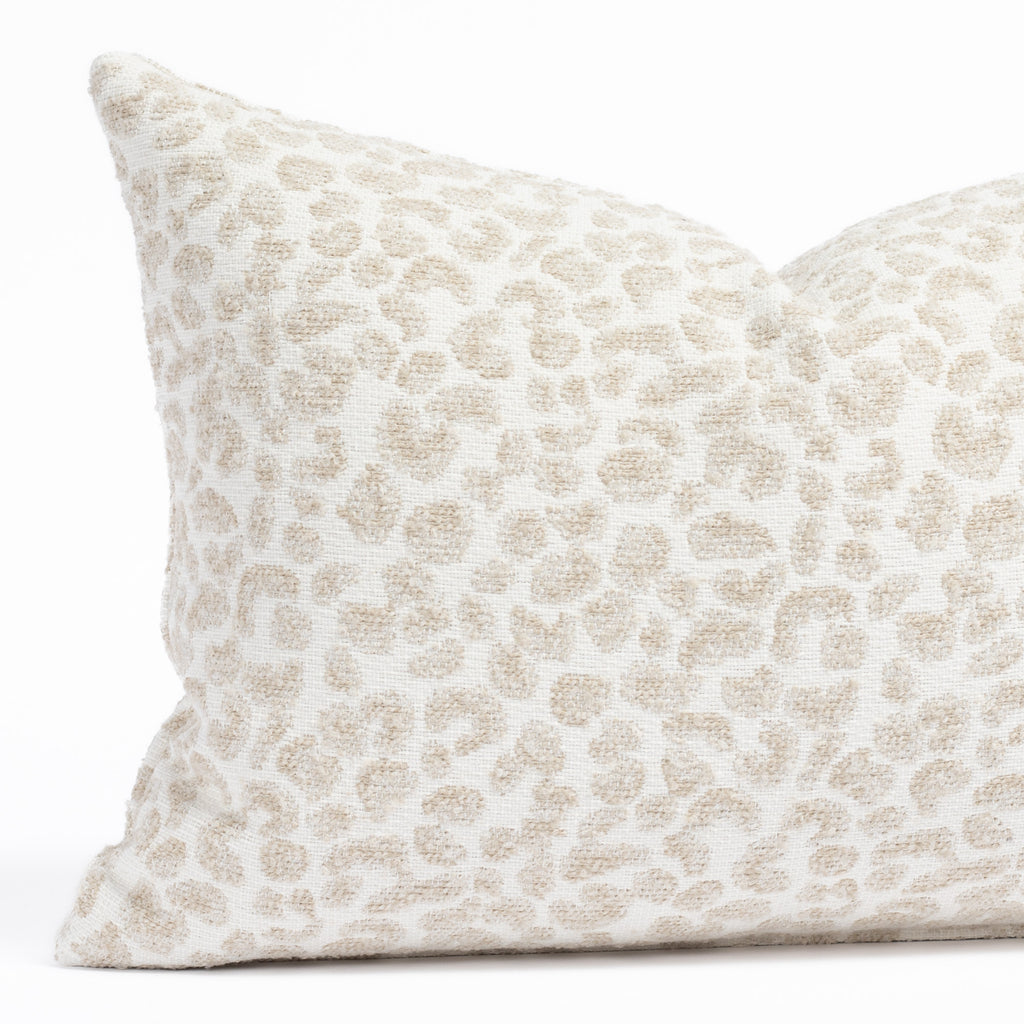 a white, cream and taupe specked cheetah patterned indoor outdoor lumbar pillow : close up view