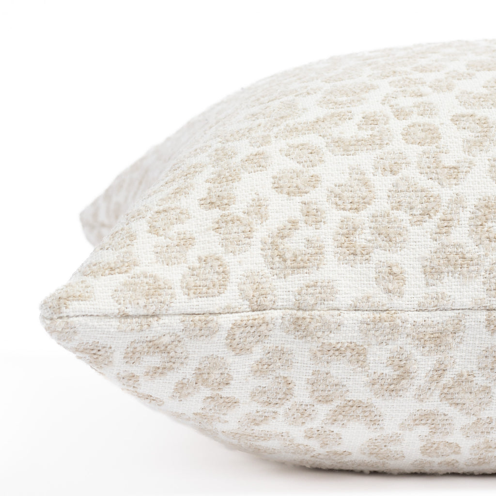a creamy white and taupe beige speckled cheetah patterned indoor outdoor pillow : close up side view