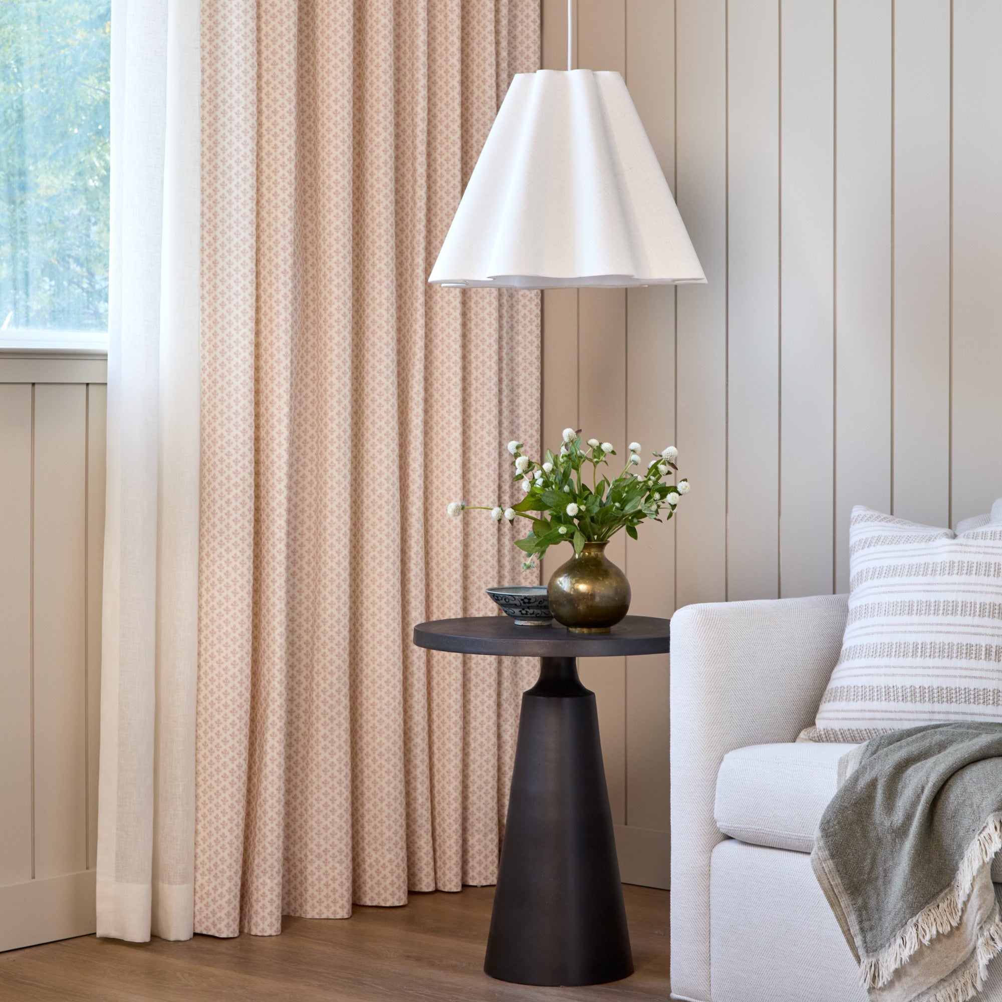 Lyra Fabric, Blush by Tonic Living — linen-blend drapery fabric with a white and light pink floral block print, shown in a living room with a Briar Stripe 20x20 Pillow, Wheat.