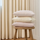 Stack of Lyra 14x20 lumbar pillows in Blush, Butter Yellow, and Berry by Tonic Living — linen-blend pillows with floral block prints.