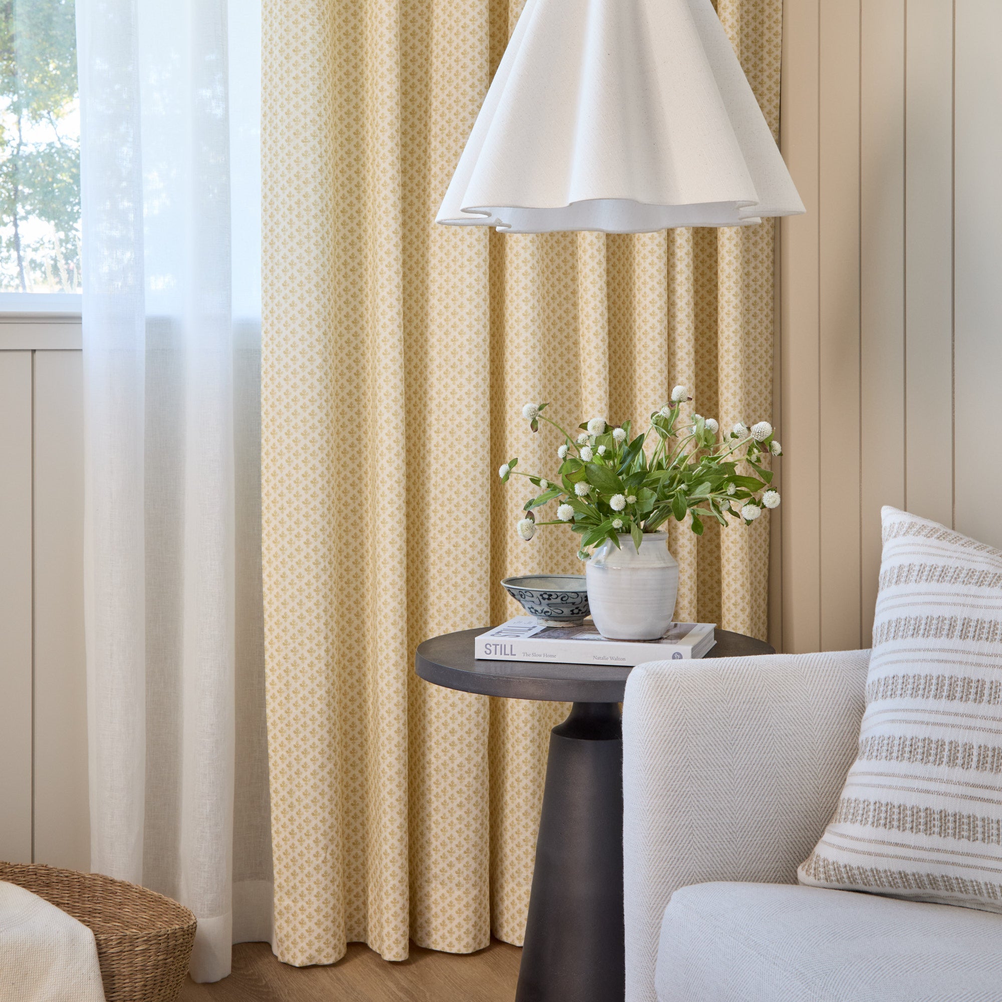 Lyra Fabric, Butter Yellow by Tonic Living — linen-blend drapery fabric with a white and yellow floral block print, shown as curtains in a living room.
