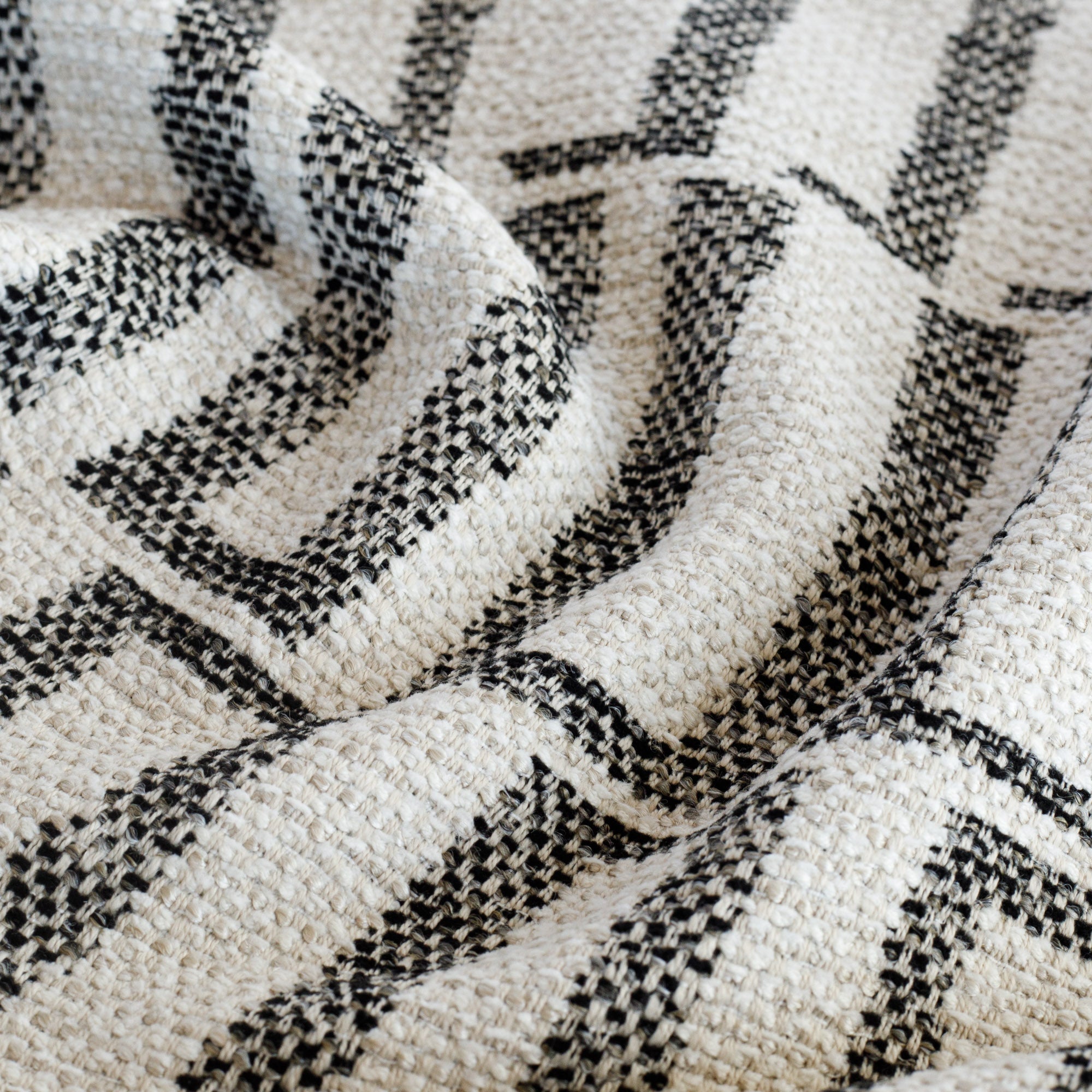 a black and sand beige geometric patterned outdoor fabric : close up view