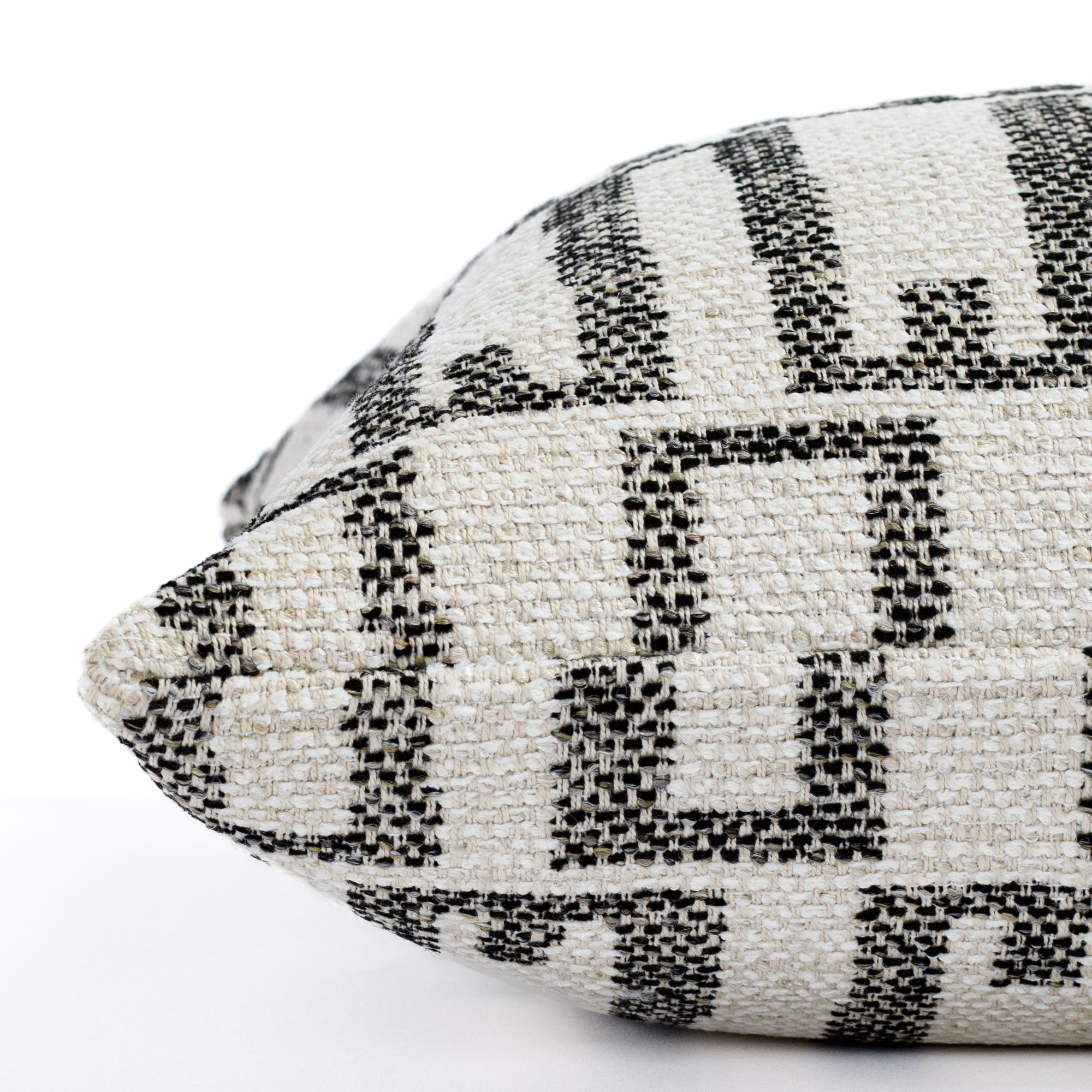 a cream and black organic geometric outdoor throw pillow : close up side view