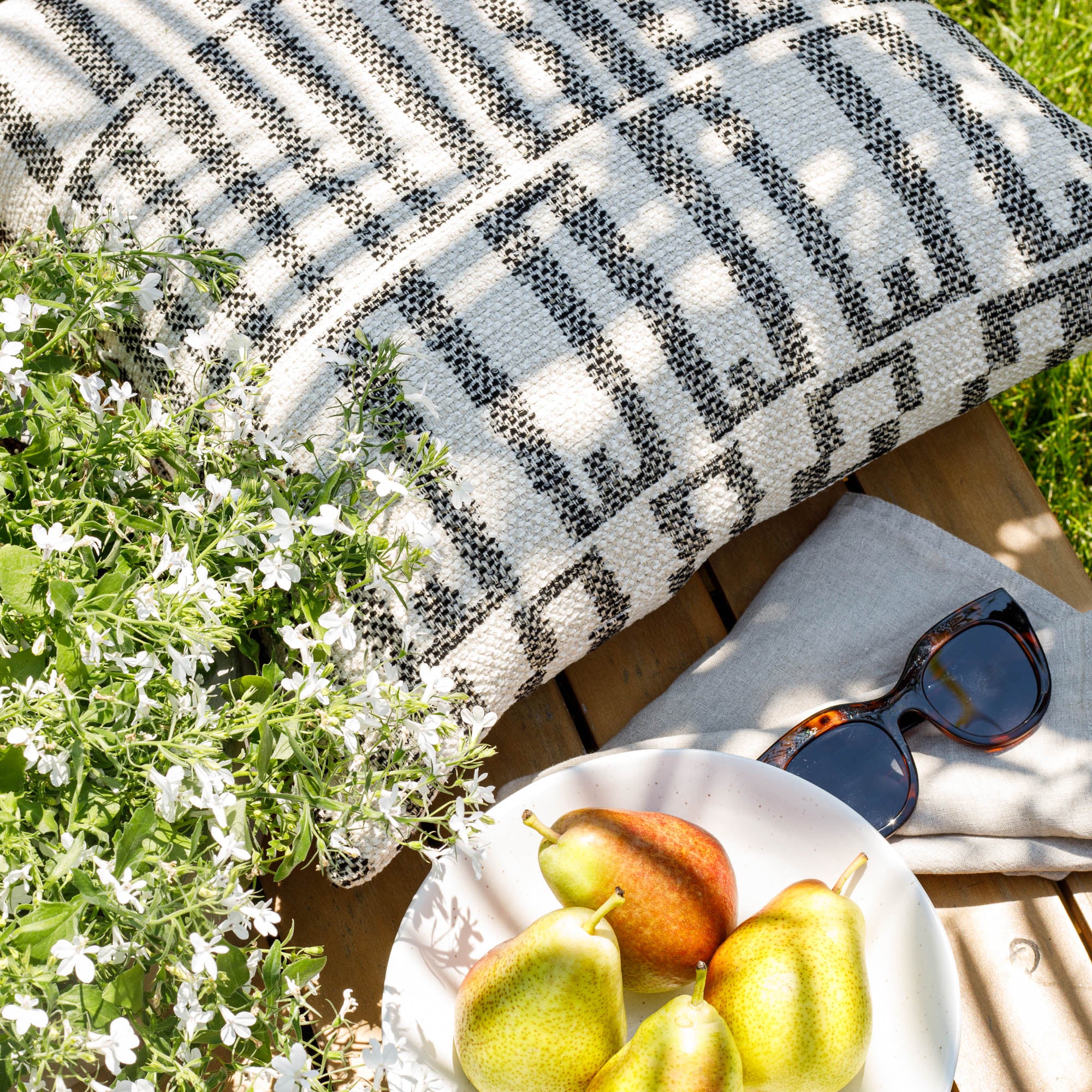 a cream and black geometric patterned outdoor throw pillow