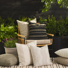 Tonic Living outdoor pillow collection styled on a patio in neutral, black, and brown tones.