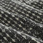 Close-up of Otto Fabric, Domino by Tonic Living — textured black and white weave with a bold, graphic houndstooth-inspired pattern.