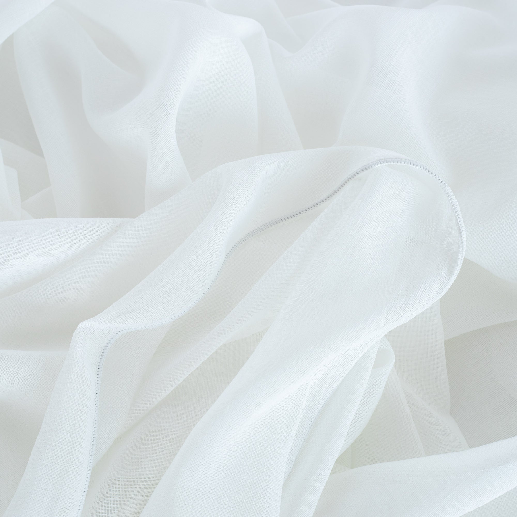 Sheer soft white curtain fabric with weighted edge