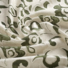 Tonic Living Paloma Olive drapery fabric featuring bold olive green blooms and scrolling leaves on a neutral oatmeal background.