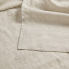 Close up of Tonic Living Positano Linen Shower Curtain showing tailored 4 inch bottom hem in stone-grey linen.