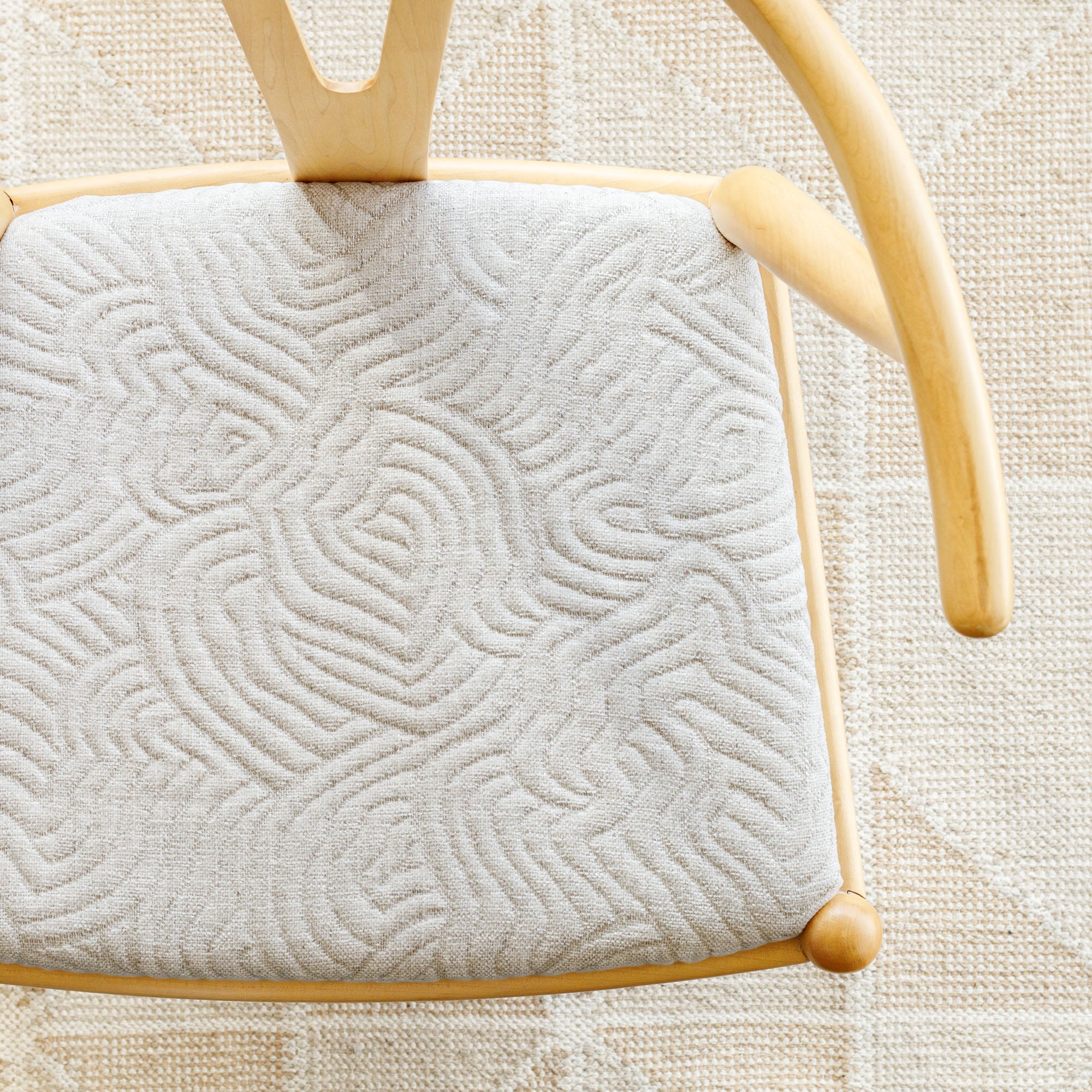 a cream quilted abstract wave patterned upholstered chair