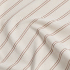 Durable Tonic Living Rexton Stripe Merlot upholstery fabric featuring classic stripes in burgundy and beige, timeless home decor fabric.