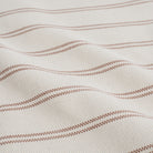 Close up of Tonic Living Rexton Stripe Merlot fabric showing ticking stripes in deep red and beige, durable upholstery material.