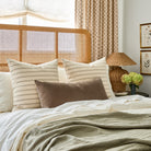 Rexton Stripe Moss 24x24 pillows styled on bed with Valentina Velvet Toffee XL lumbar cushion
