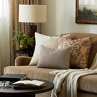 Tonic Living Crosby Stripe Truffle lumbar cushion styled on a brown velvet sofa with neutral textured and patterned throw pillows.