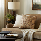 Tonic Living Rupert Parchment cream bouclé pillow styled on a sofa with Zuri Driftwood medallion throw pillow.