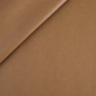 Tonic Living Smythe Faux Leather Fabric in Saddle, a saddle brown high-performance upholstery fabric with a natural leather look.