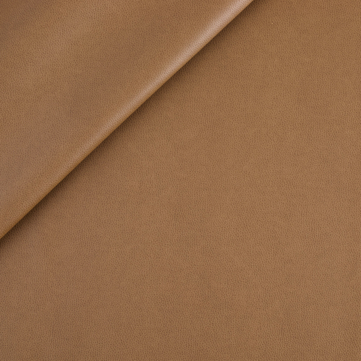Tonic Living Smythe Faux Leather Fabric in Saddle, a saddle brown high-performance upholstery fabric with a natural leather look.