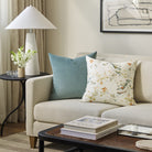 Tonic Living Sterling Velvet Lake aqua blue pillow styled on a sofa with a floral decorative cushion in a living room.