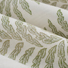 Close up of Tonic Living Swoon Sunbrella Sage fabric showing green and white botanical stripe detail.