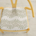 Tonic Living Swoon Sunbrella Sage indoor/outdoor upholstery fabric on a dining chair seat in green botanical stripe.
