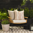 Tonic Living Talisman Sand outdoor cushion styled on a chair with Swoon Terracotta 20x20 pillow in an outdoor setting.