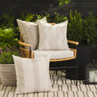Tonic Living outdoor pillow collection featuring neutral beige and white cushions styled on a patio.