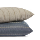Stack of Tonic Living Talisman 22x22 outdoor pillows in Sand and Denim featuring embroidered stripe designs.
