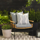 Tonic Living Swoon Denim outdoor cushion styled on a chair with Troy Denim 22x22 pillow on an outdoor patio.