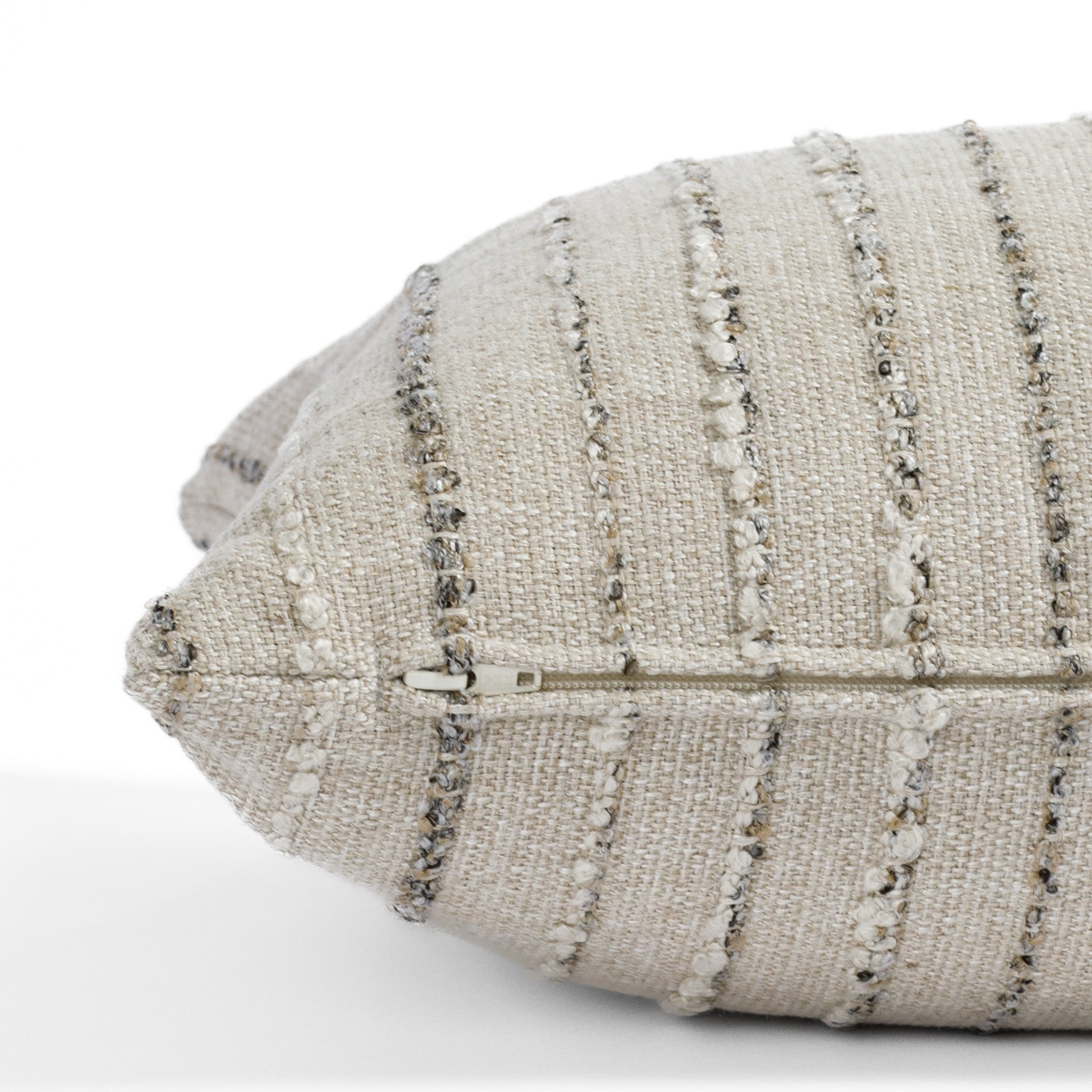 a neutral earth toned striped extra long lumbar pillow : close up zipper detail