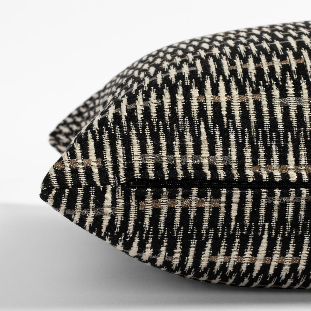 a black, brown and tan modern patterned throw pillow : zipper detail