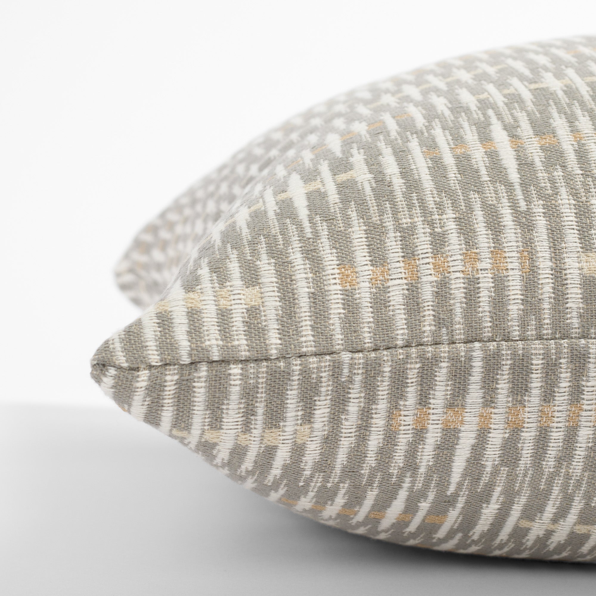 a gray, beige and cream graphic abstract pattern throw pillow : side view