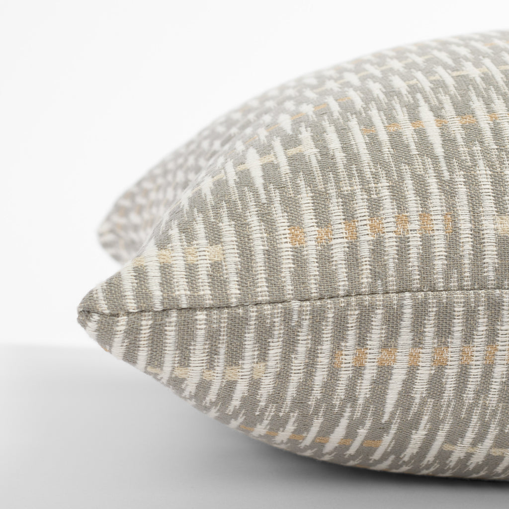 a gray, beige and cream graphic abstract pattern throw pillow : side view