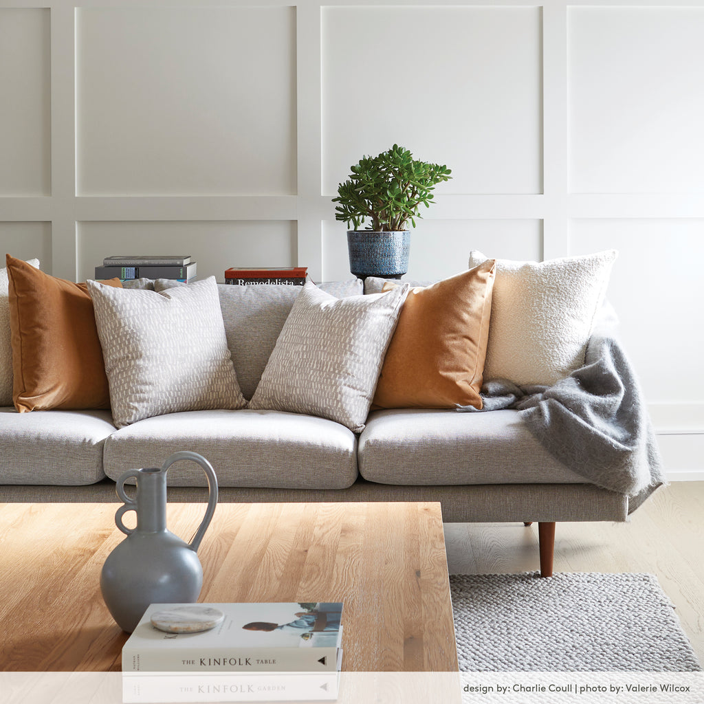 modern living room with neutral pillows on a grey sofa. Interior design by Charlie Coull