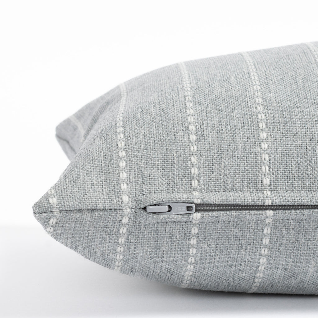 a blue gray and white stripe lumbar pillow : zipper detail