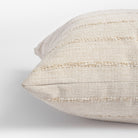 close up view of a creamy beige pillow with tonal textured stripe