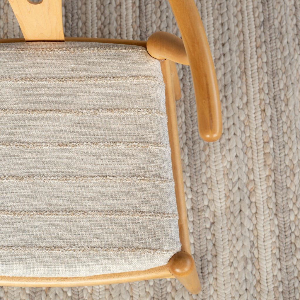 Handlavet Raffia textured stripe fabric shown on an upholstered chair seat