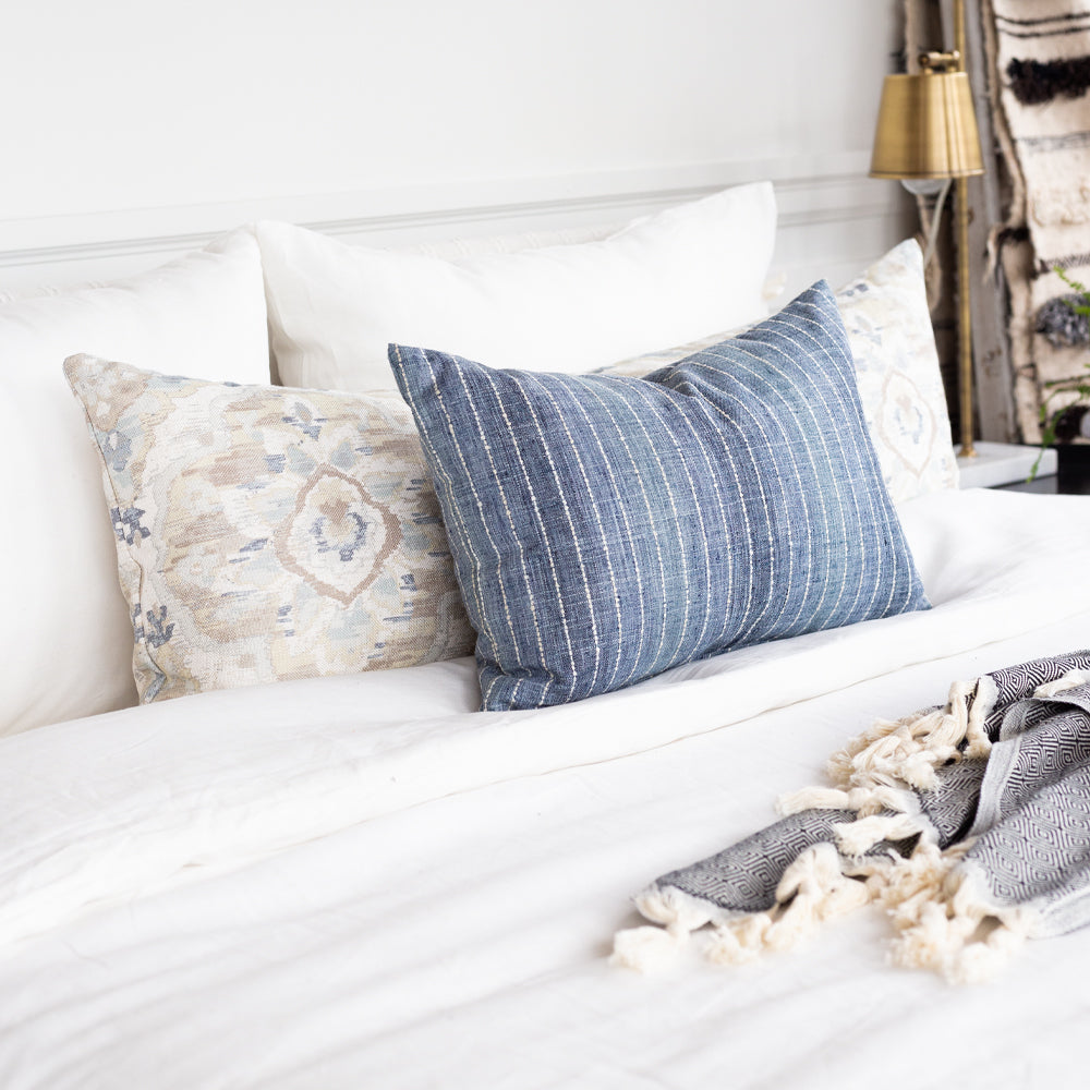 Hyden Lake Blue Lumbar Pillow on a bed