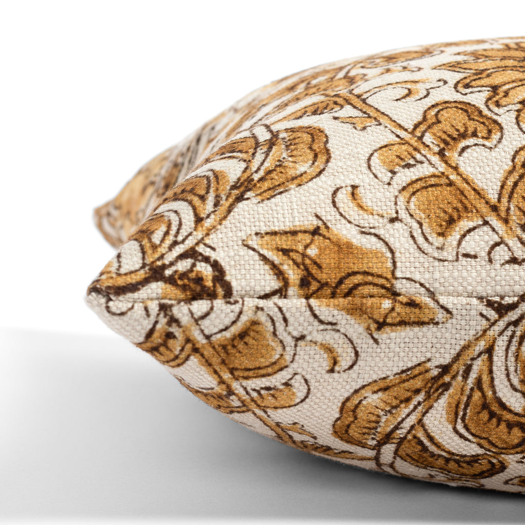a gold, ochre and brown floral print throw pillow : side view