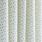 a white and green inky polka dot print curtain fabric