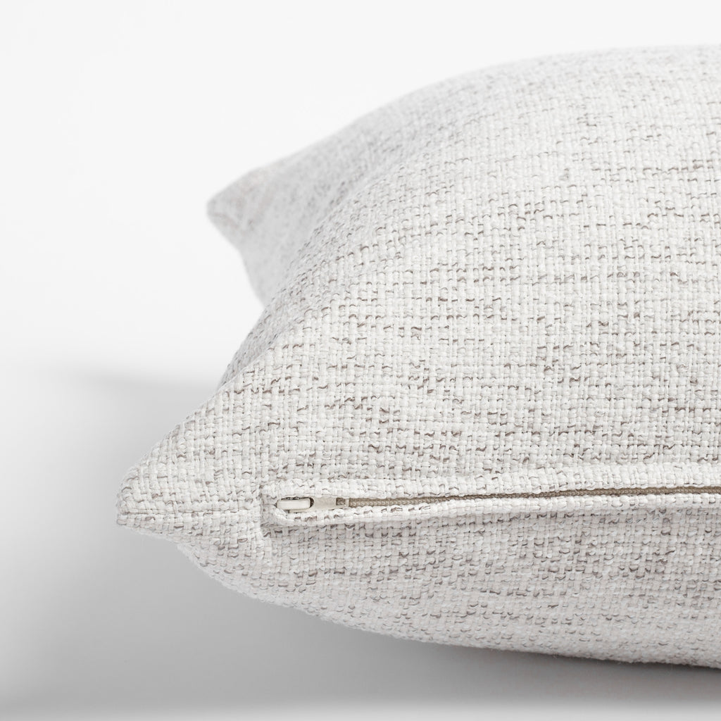 Preston Birch, a heathered cream and light gray indoor outdoor pillow: zipper detail
