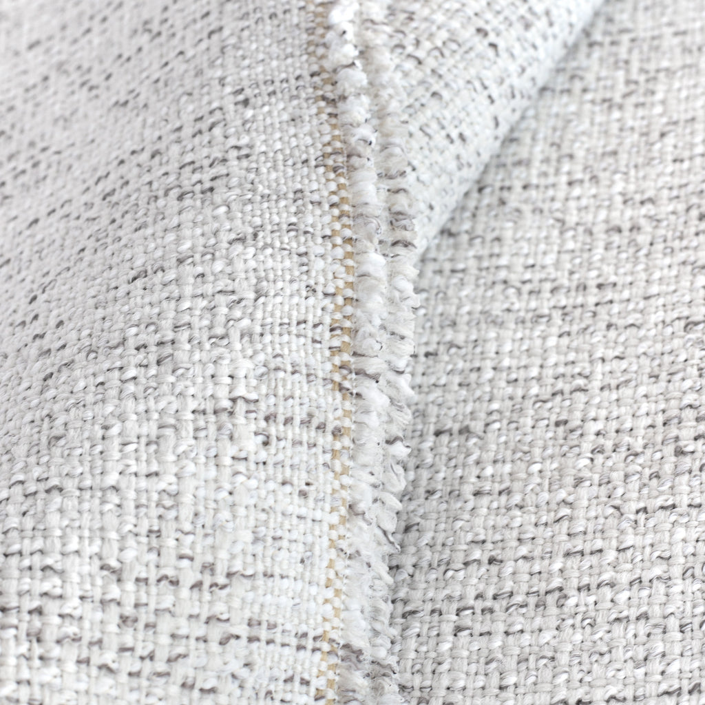 Close up view: a light cream indoor outdoor upholstery fabric, with strands of warm gray