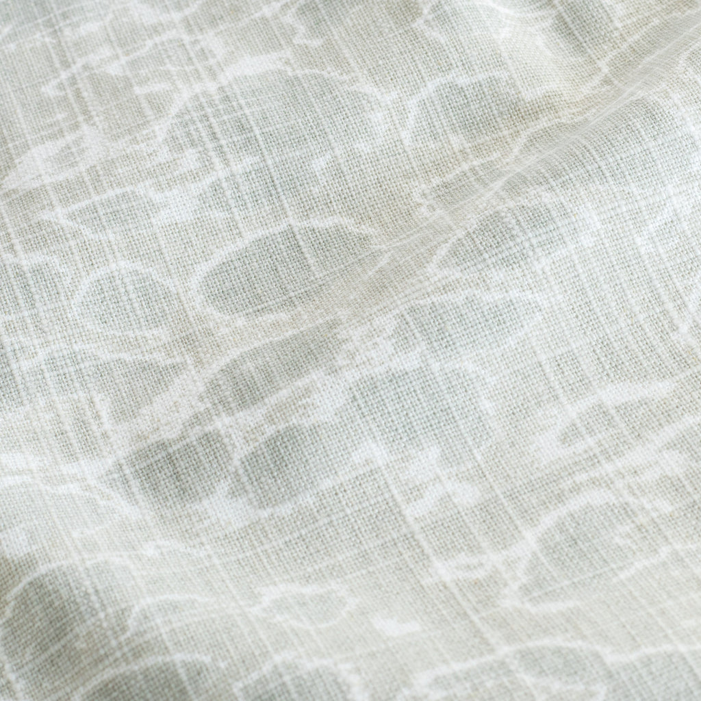a watery mineral green and white abstract dabbled water print fabric : close up view