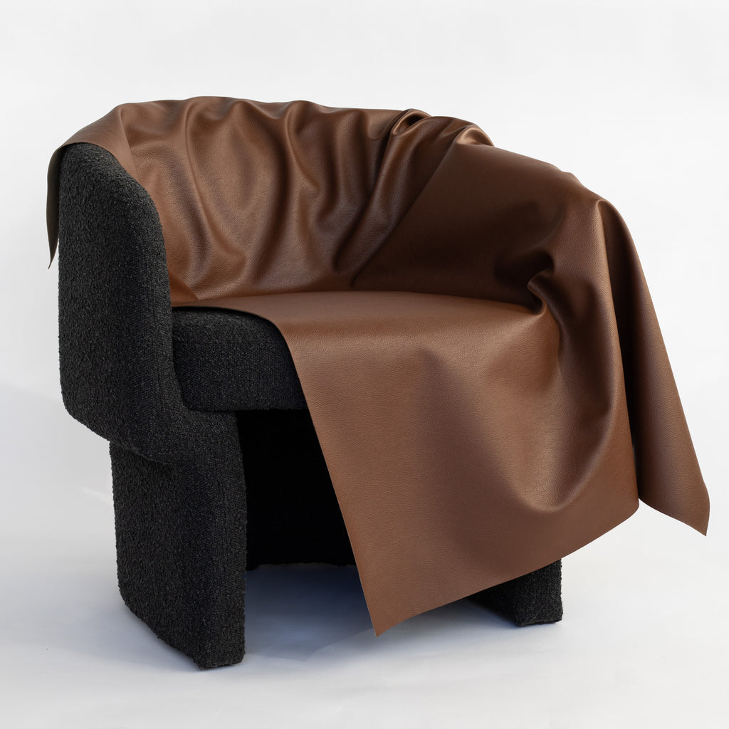 a deep brown vinyl faux leather performance upholstery fabric draped on a chair 