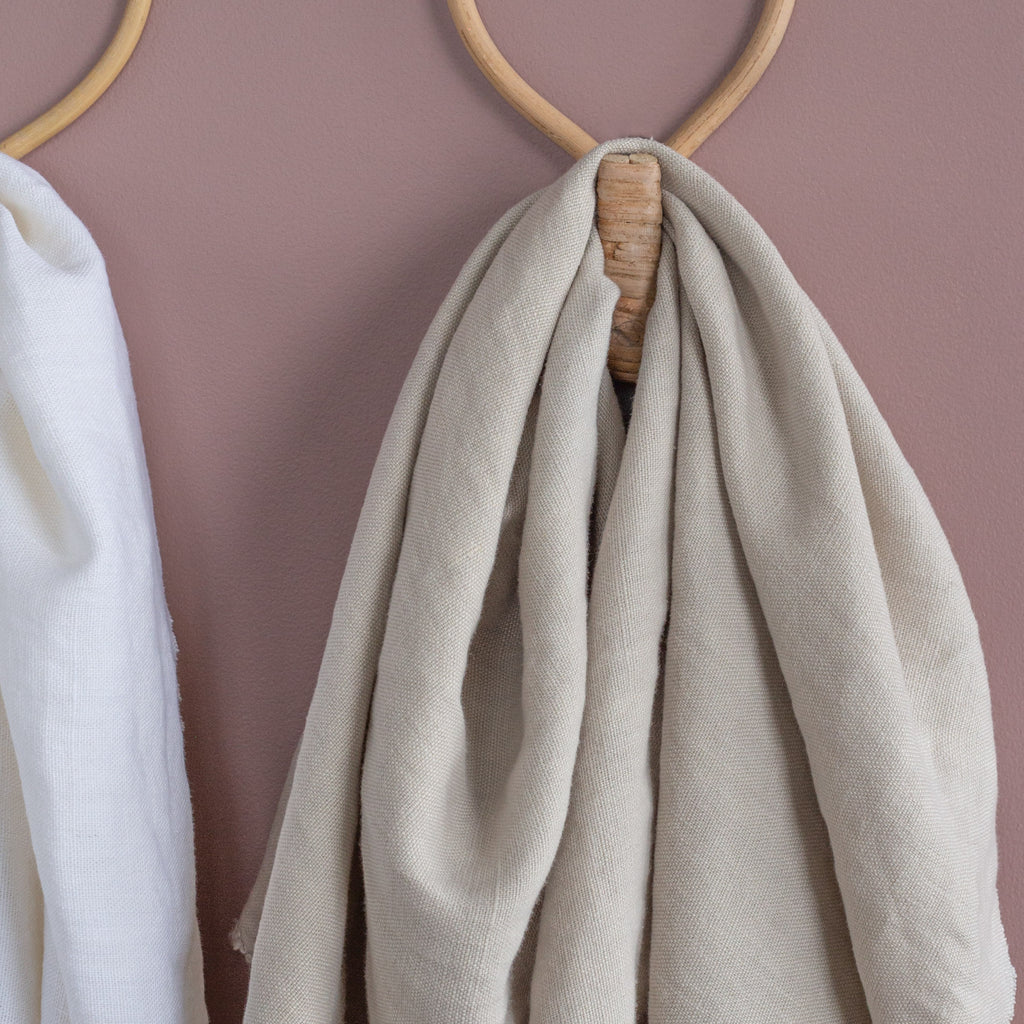 warm neutral beige linen fabric draped on a wall hook