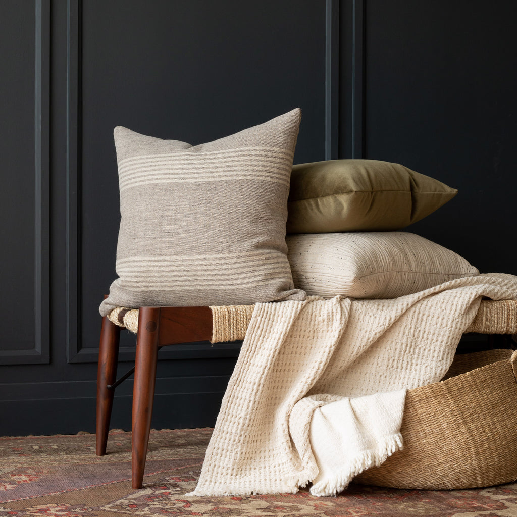 Stockton Stripe Graphite, a linen throw pillow, in shades of natural tan and faded black stacked with Balsam green Valentina velvet and Dunes natural