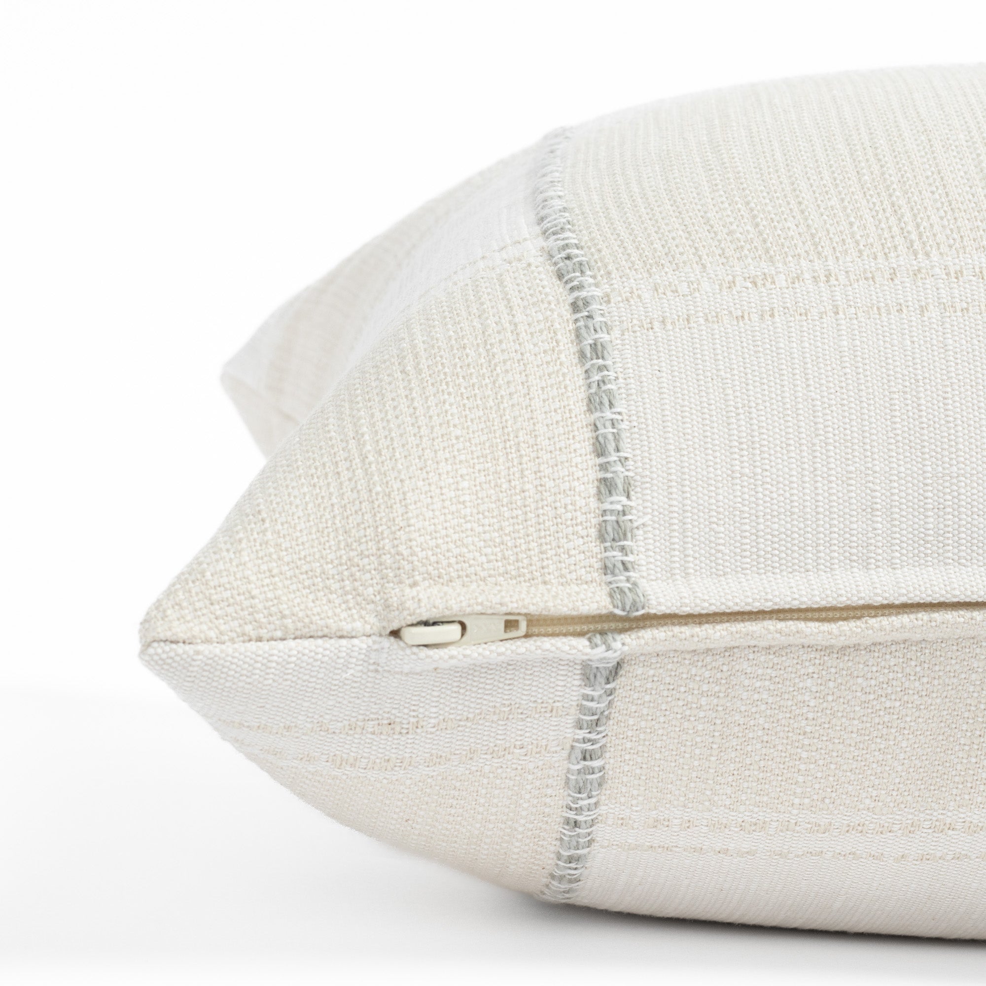 a chunky light blue stripe and cream patchwork pattern bolster pillow : close up zipper detail