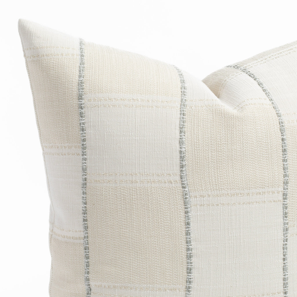 a chunky light blue stripe and white cream patchwork patterned throw pillow : corner close up view