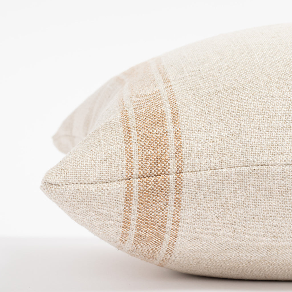 a faded rust and cream wide vertical ticking stripe lumbar pillow : close up side view