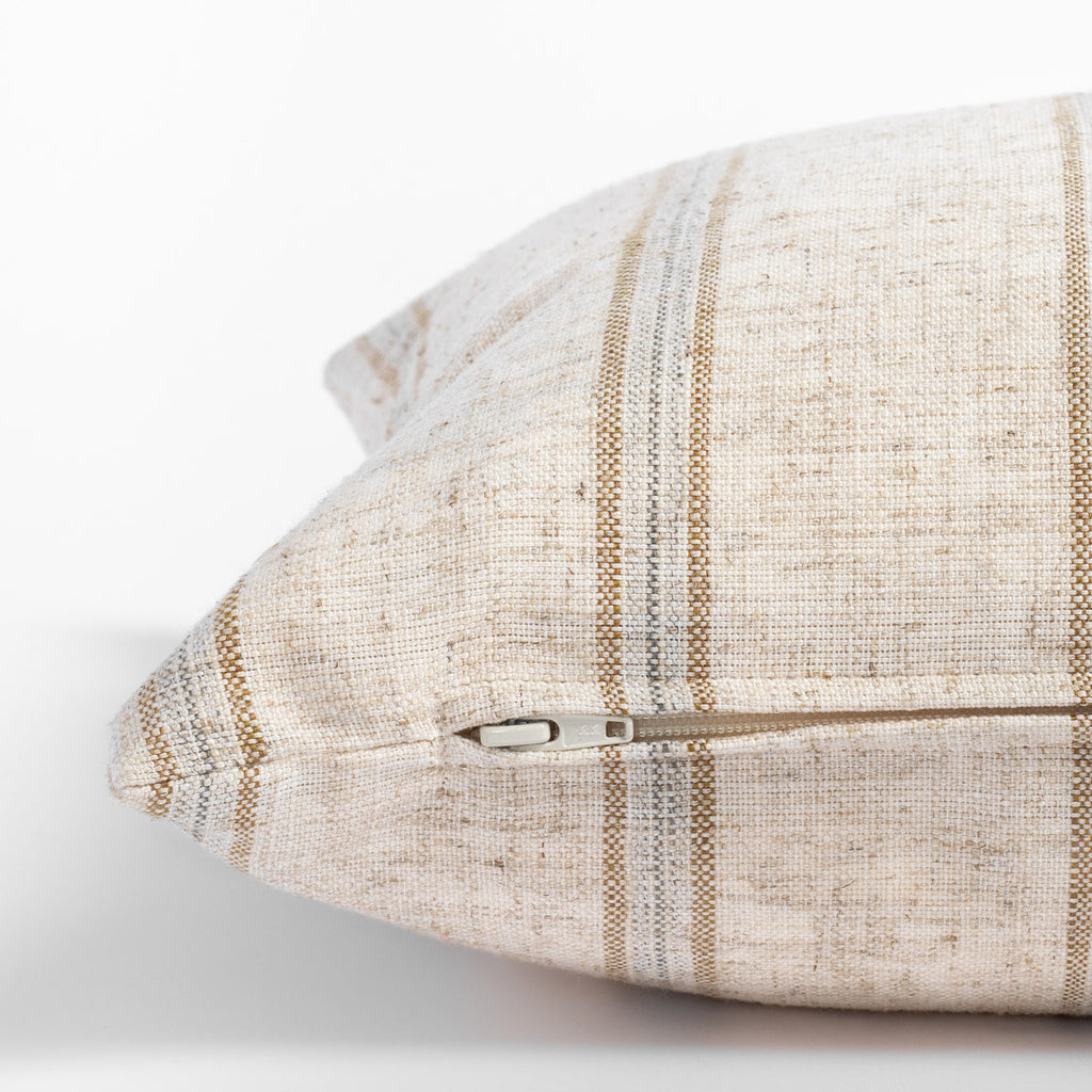 Yarmouth Stripe Sandstone, a beige lumbar pillow with golden sand and gray vertical stripes : close up zipper view